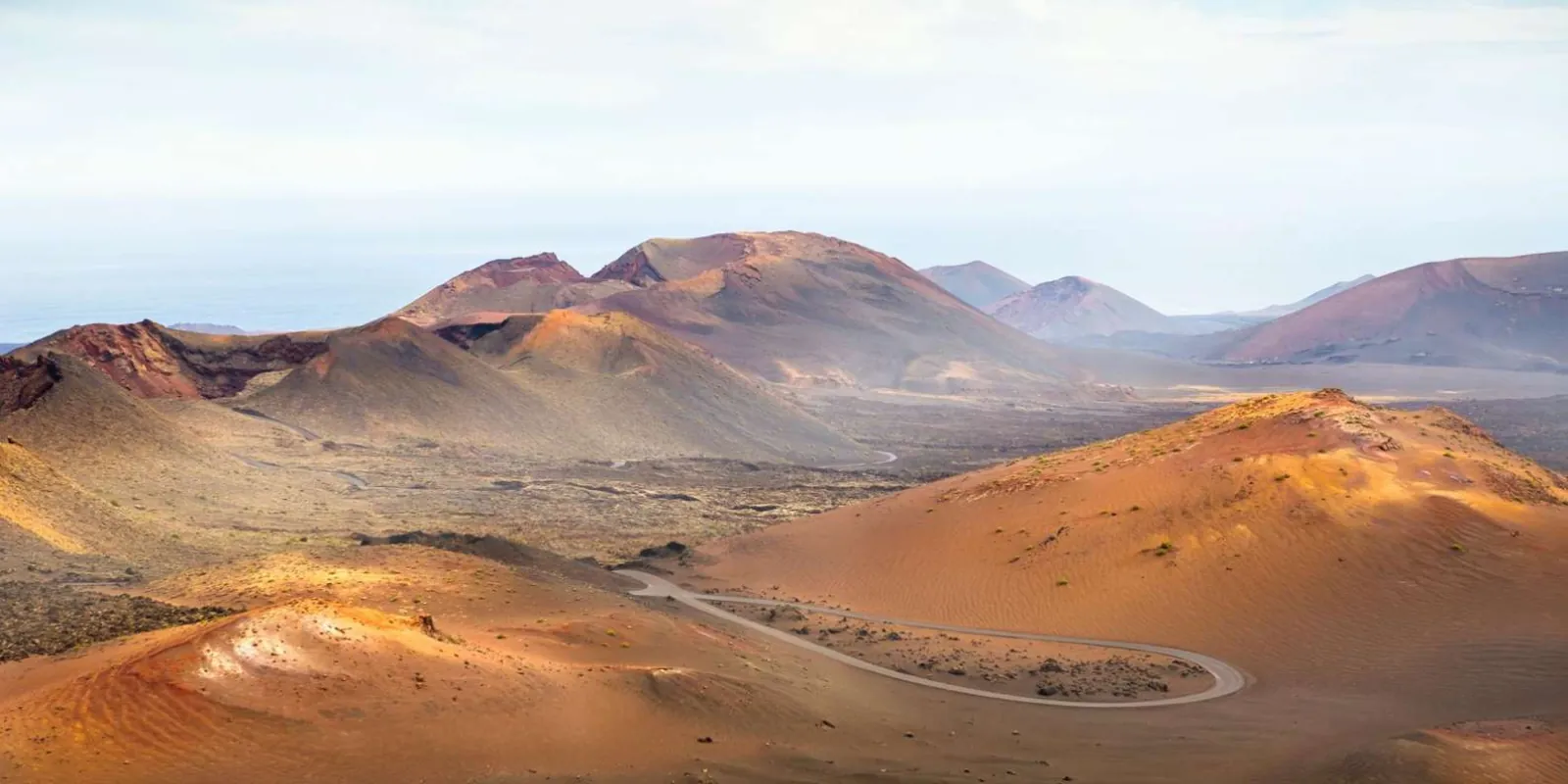 The Ruta de los Volcanes road winding between ochre and red craters in Timanfaya